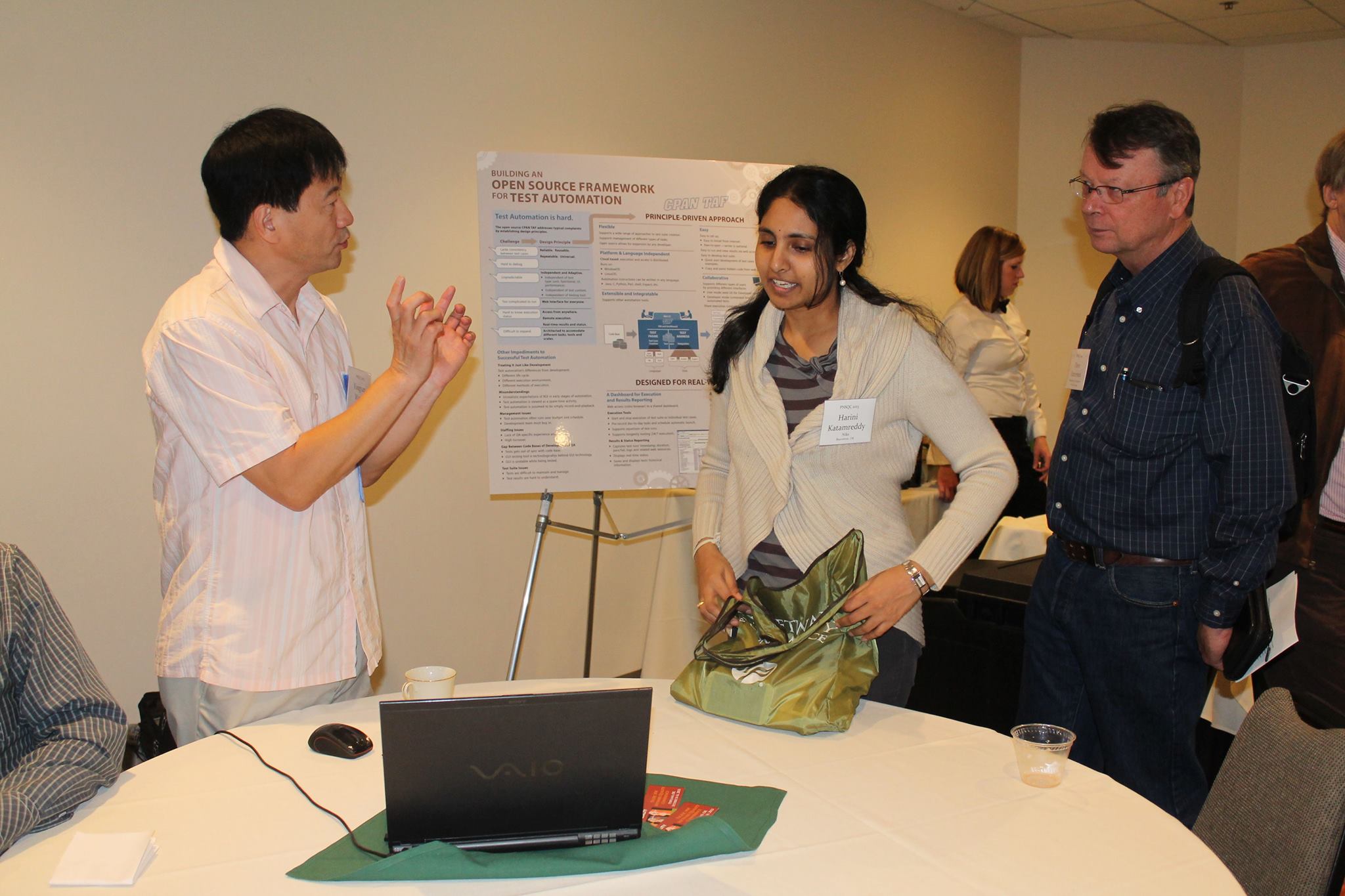 Attendees talking with a presenter at a PNSQC poster session