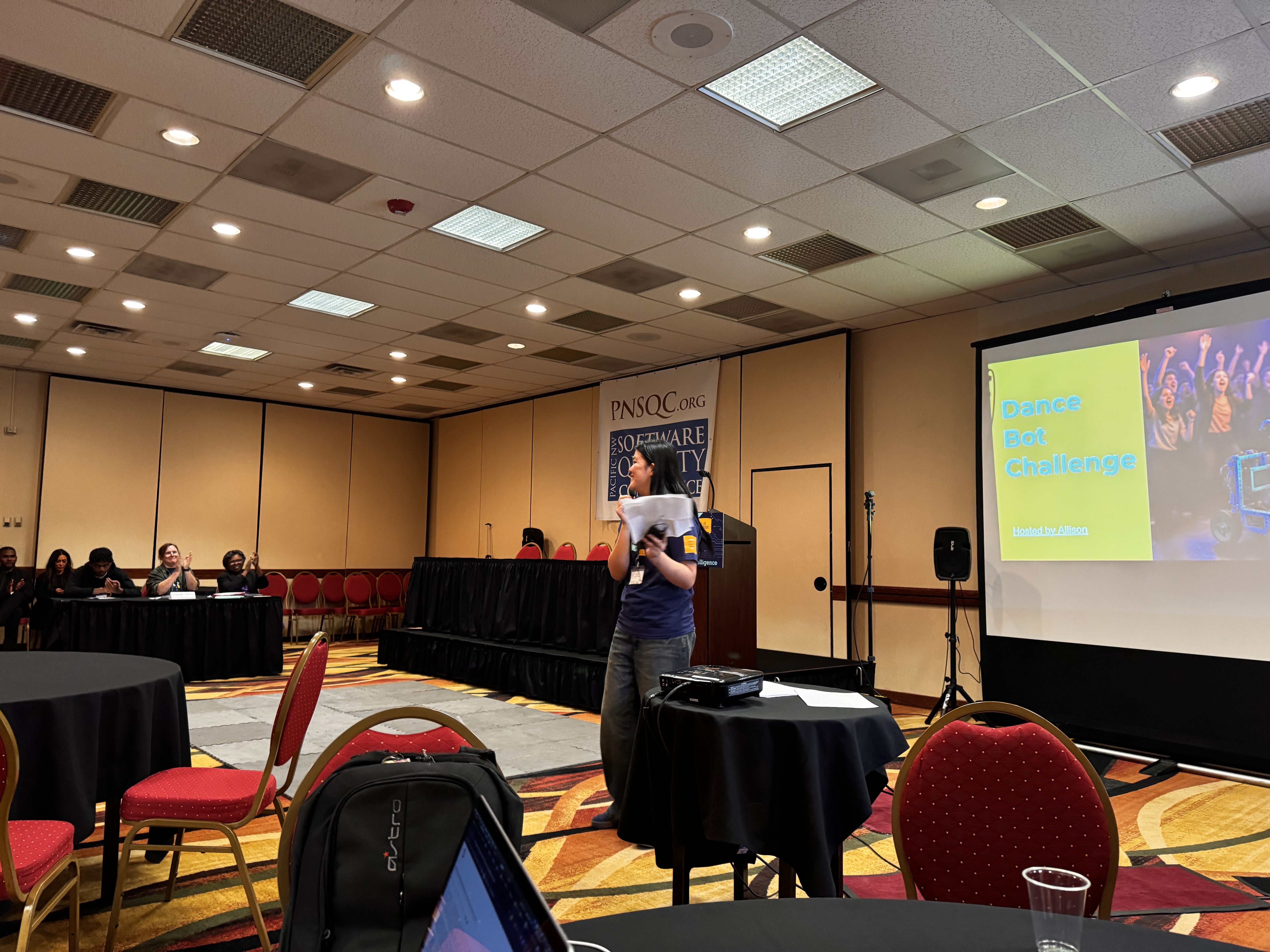 High school students at the PNSQC STEM Fair with robotics, AI projects, and technology displays